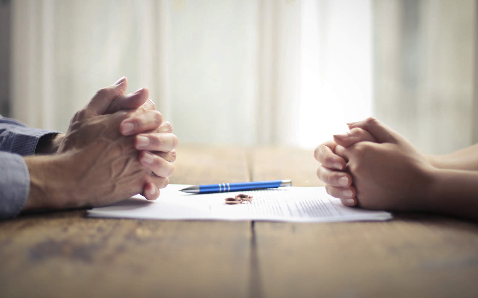Paar vor Vertrag und Eheringen - bildlich für Scheidung